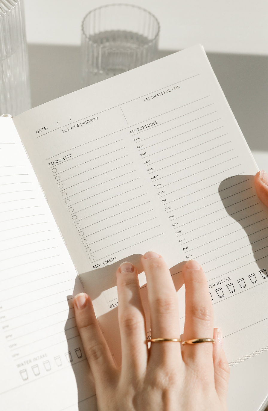 Wellness Planner spine close-up showing full feature list: habits, gratitude, goals, meals, workouts, monthly layouts, daily pages | Strawberry Goose