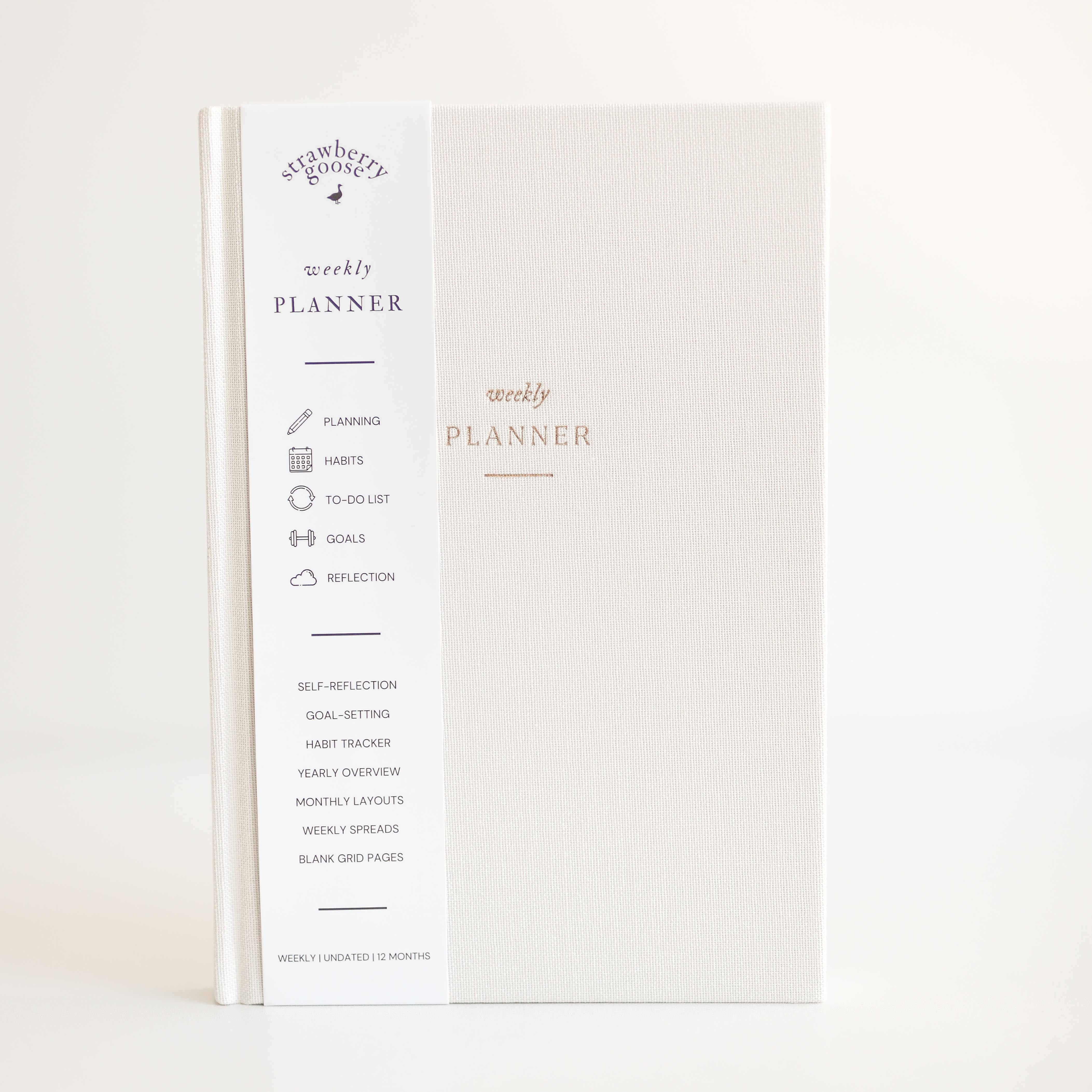 Weekly planner book with branding on a light background