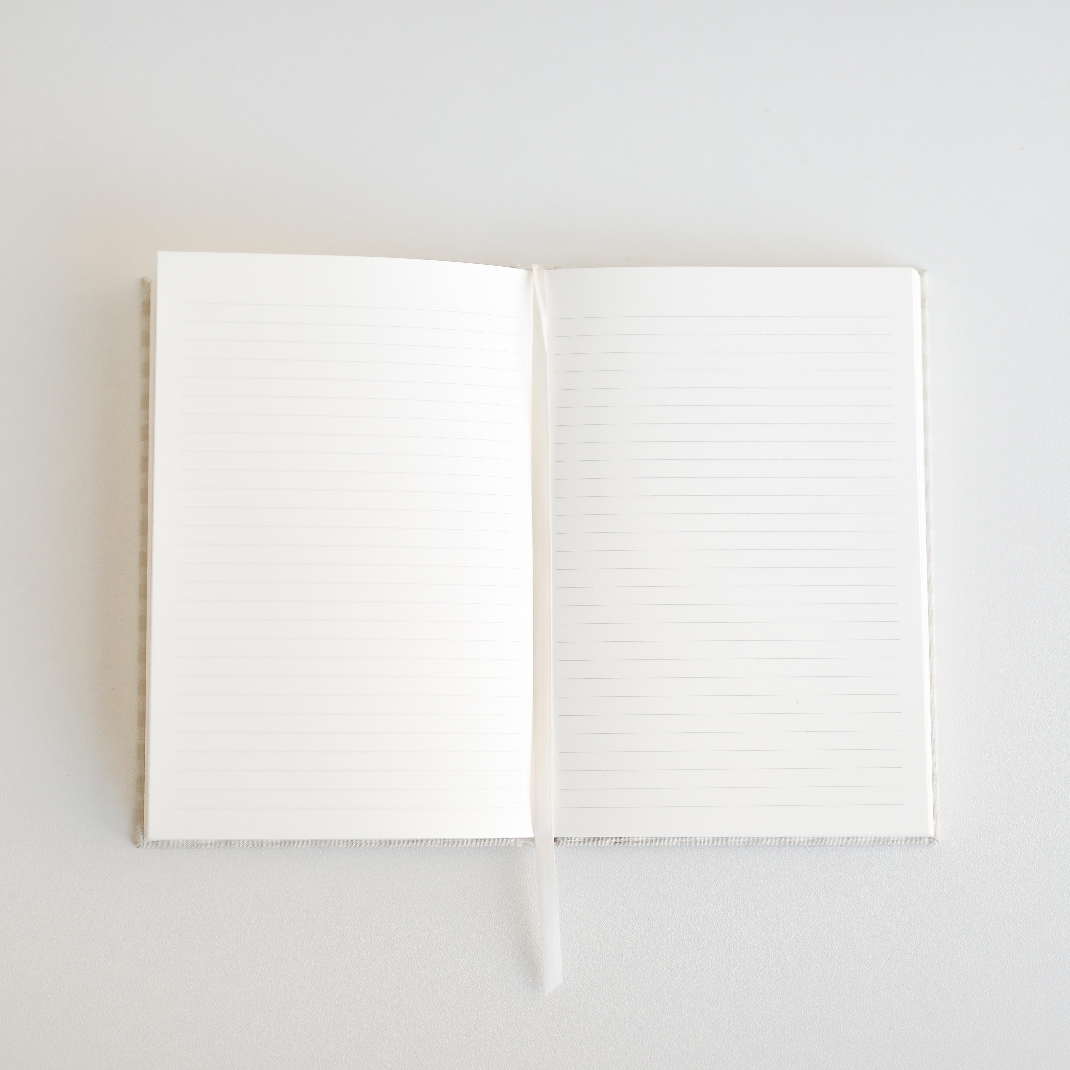 Open book with blank lined pages on a light gray background